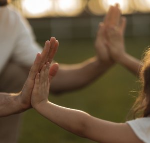 Erwachsener und Kind geben sich ein high five
